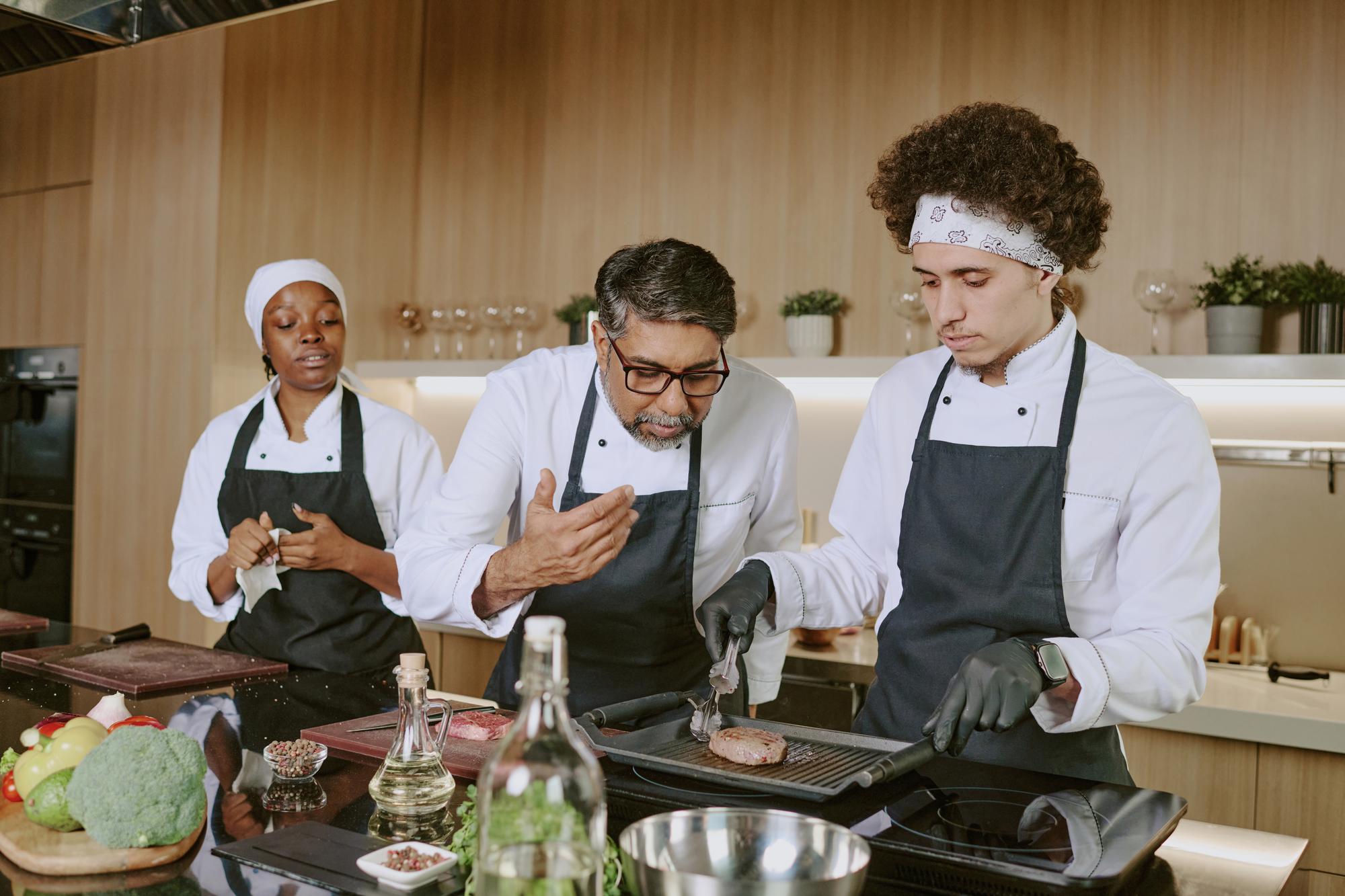 Chef mentoring a small kitchen team